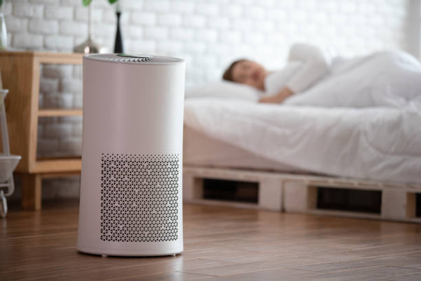 woman sleep with Air purifier in cozy white bed room for filter and cleaning removing dust PM2.5 HEPA in home,for fresh air and healthy life,Air Pollution Concept
